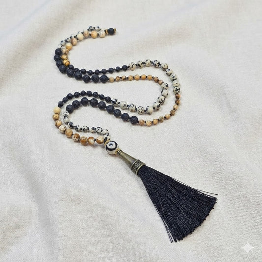 שרשרת מאלה אבני חן בעבודת יד עם ג'ספר דלמטי, פיקצ'ר ג'ספר ובזלת, חרוזי אגת טיבטי דוגמת עין וגדיל שחור, מאלה ארוכה 70 ס"מ מונחת על בד טבעי