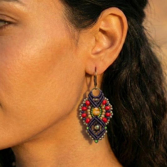 עגילי מקרמה אינקה סגול כהה ואדום עם חרוזי זכוכית על אוזן דוגמנית באור טבעי