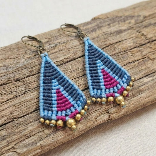 עגילי מקרמה טיפי כחול סגול - זוג מלא בעבודת מקרמה עם שורת חרוזי בראס מוזהבים, מונחים על ענף עץ טבעי