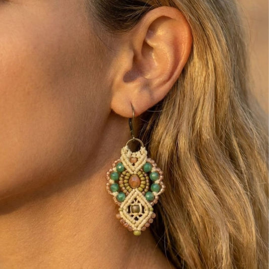 עגילי מקרמה אינקה שמנת וירוק עם חרוזי זכוכית על אוזן דוגמנית באור טבעי