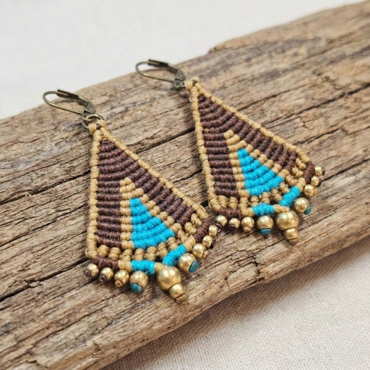 עגילי מקרמה טיפי חום וטורקיז - זוג מלא בעבודת מקרמה עם שורת חרוזי בראס, מונחים על ענף עץ טבעי