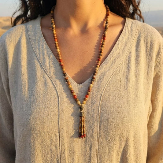 מאלה 'אלמנט האש' על דוגמנית עם גלבייה בצבע טבעי במדבר באור שקיעה, שרשרת מאלה לאישה עם פיקצ'ר ג'ספר, קרנליאן וג'ספר אדום, עד אמצע החזה